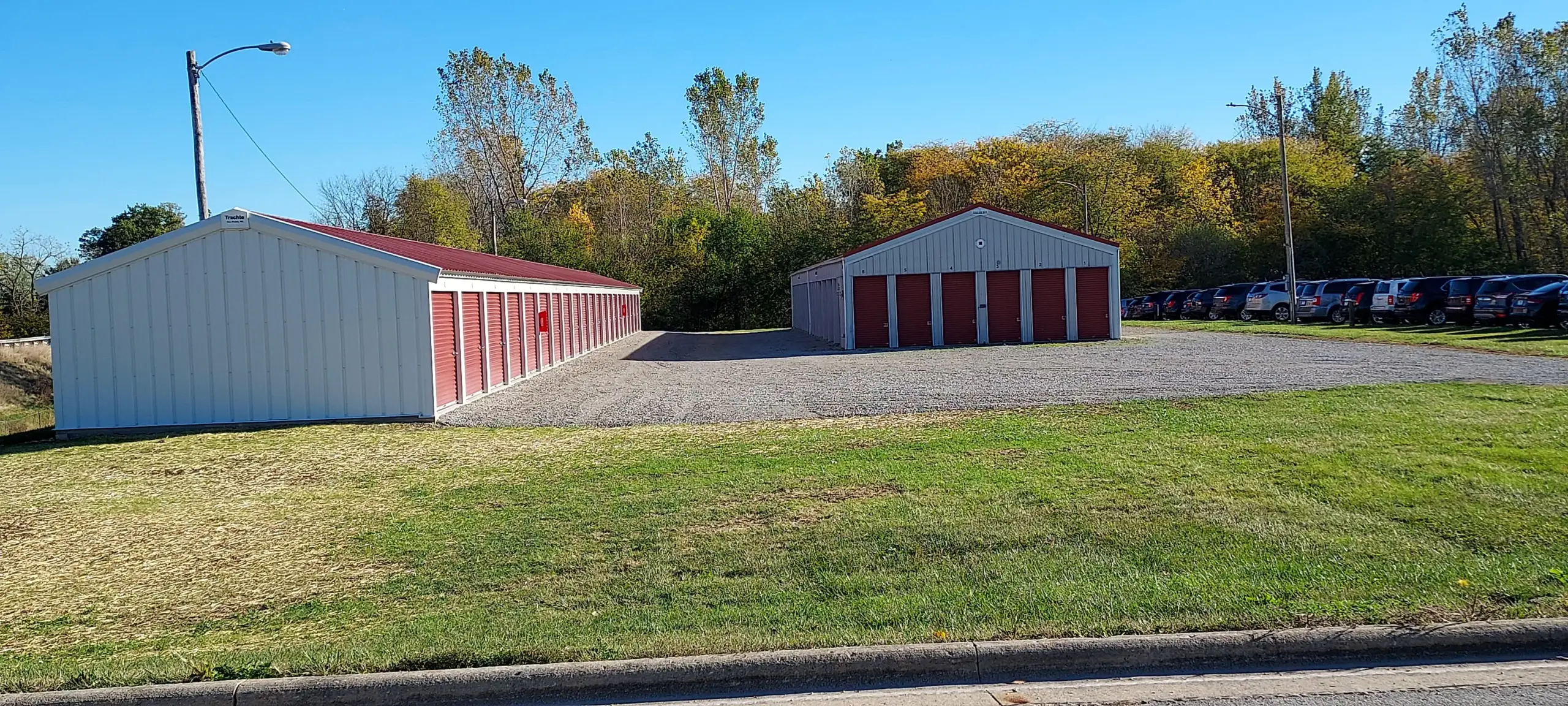 Storage units with red doors and grassy area